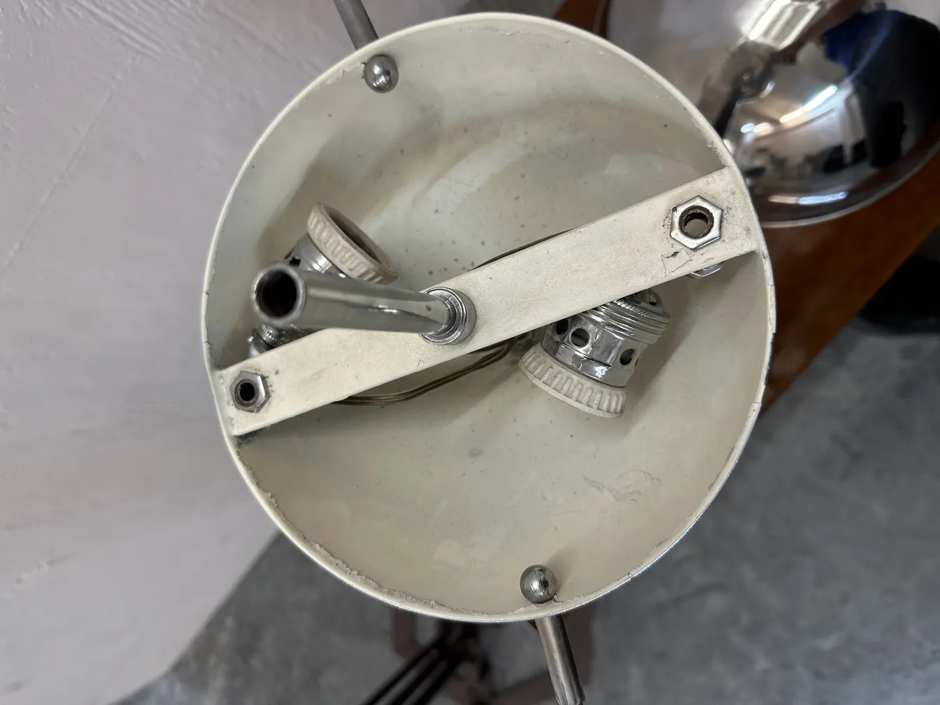 Top view of an antique table lamp with a white interior, focusing on the socket and metal details.