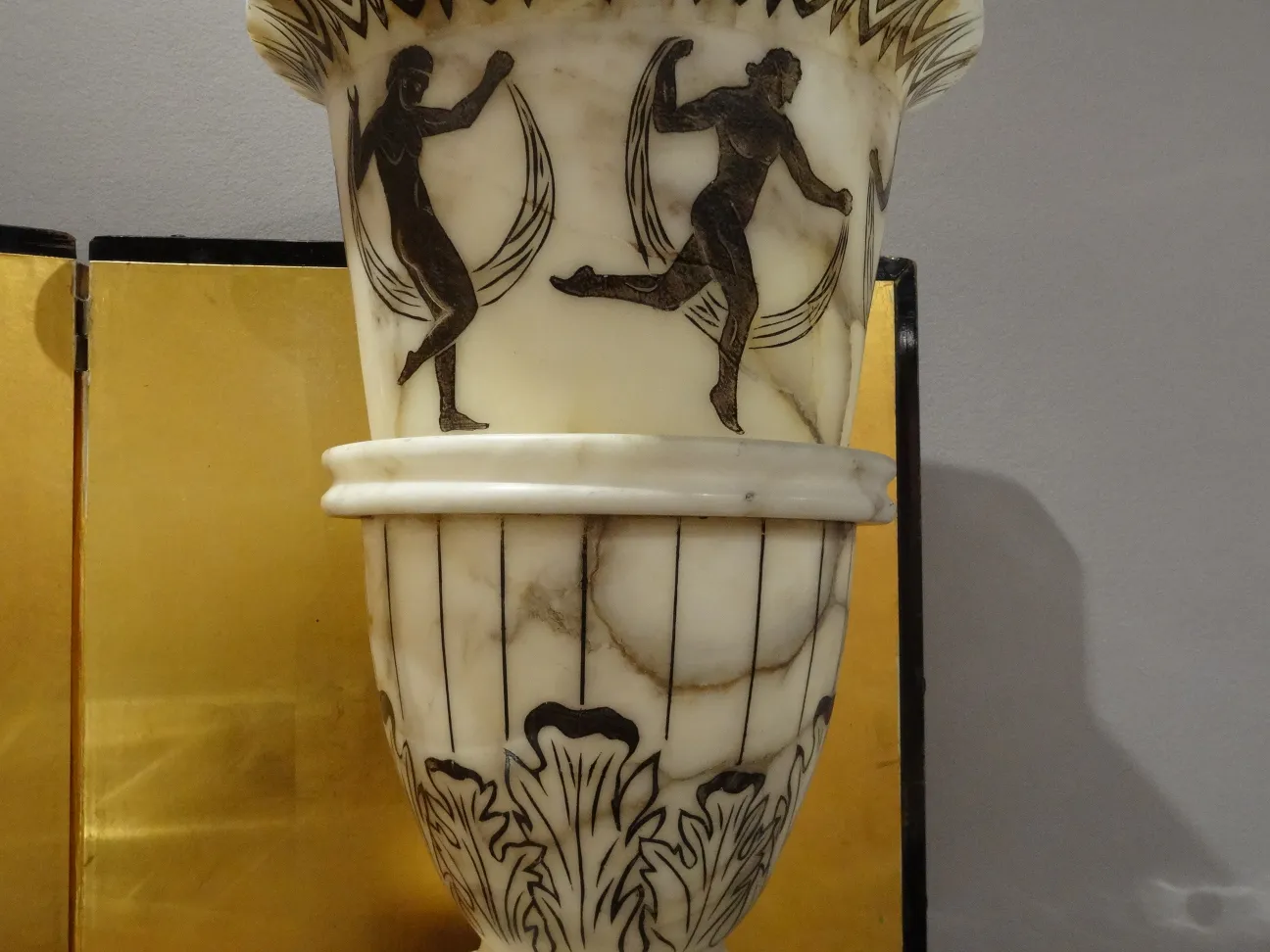 Antique floor lamp featuring decorative figures in a warm setting.