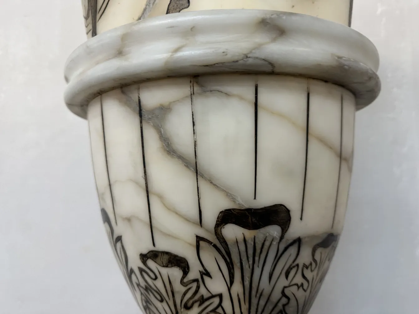 Close-up view of two antique floor lamps with detailed decorations shown in a light setting.