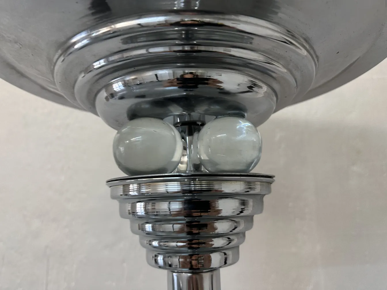Close-up view of two antique floor lamps with chrome elements against a light background.