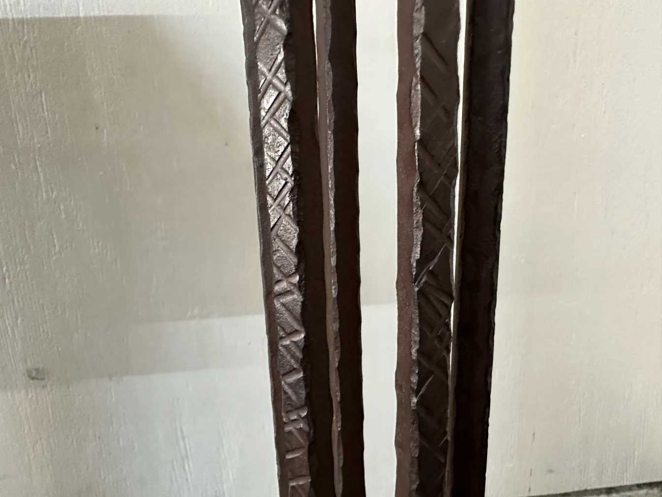 Two antique floor lamps, decorative and elegant, in a subdued setting. Featuring embossed details.