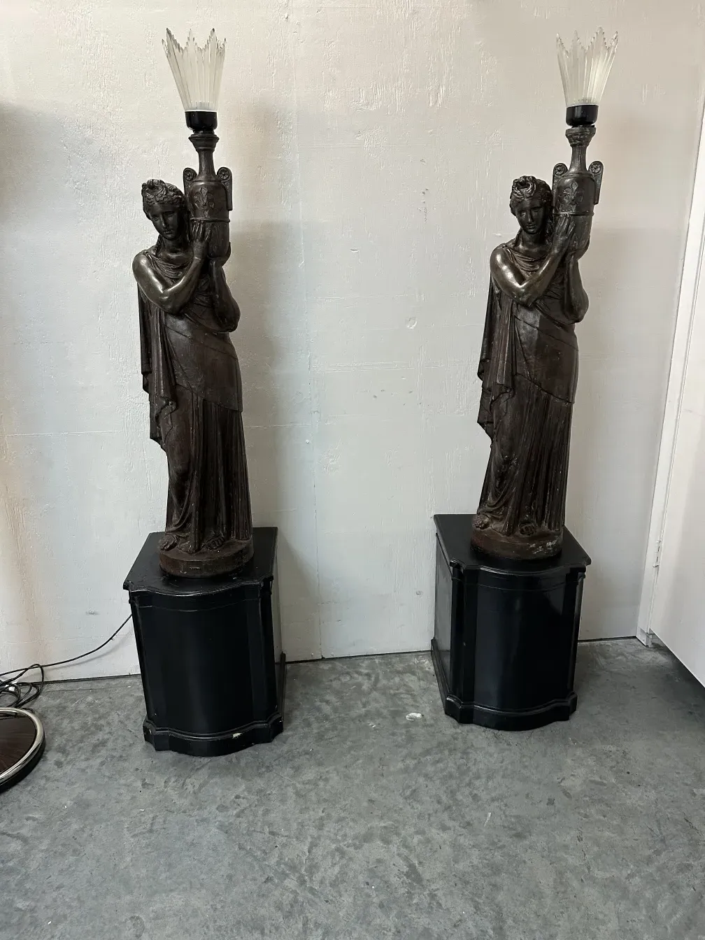 Among the antiques, there are two decorative floor lamps with a dark finish and sculptural details.