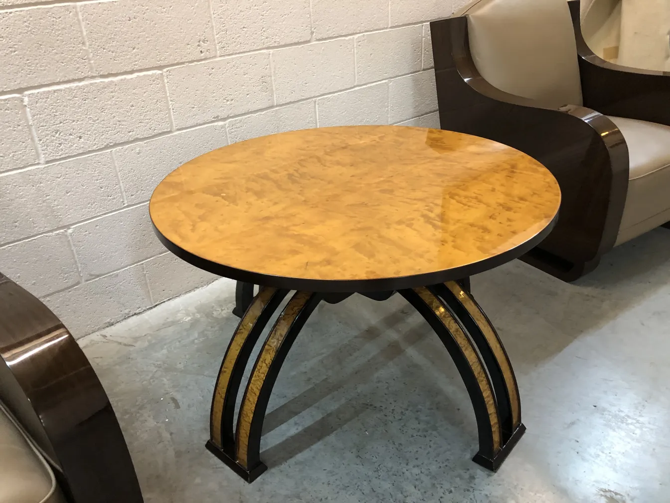 Antique coffee table with a round top and decorative legs in a modern setting.