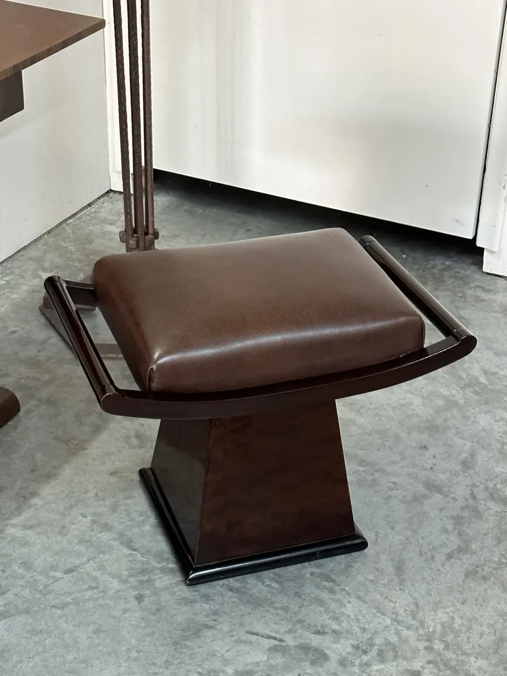 antique brown sidewalk stool with backrest and elegant design in a neutral setting