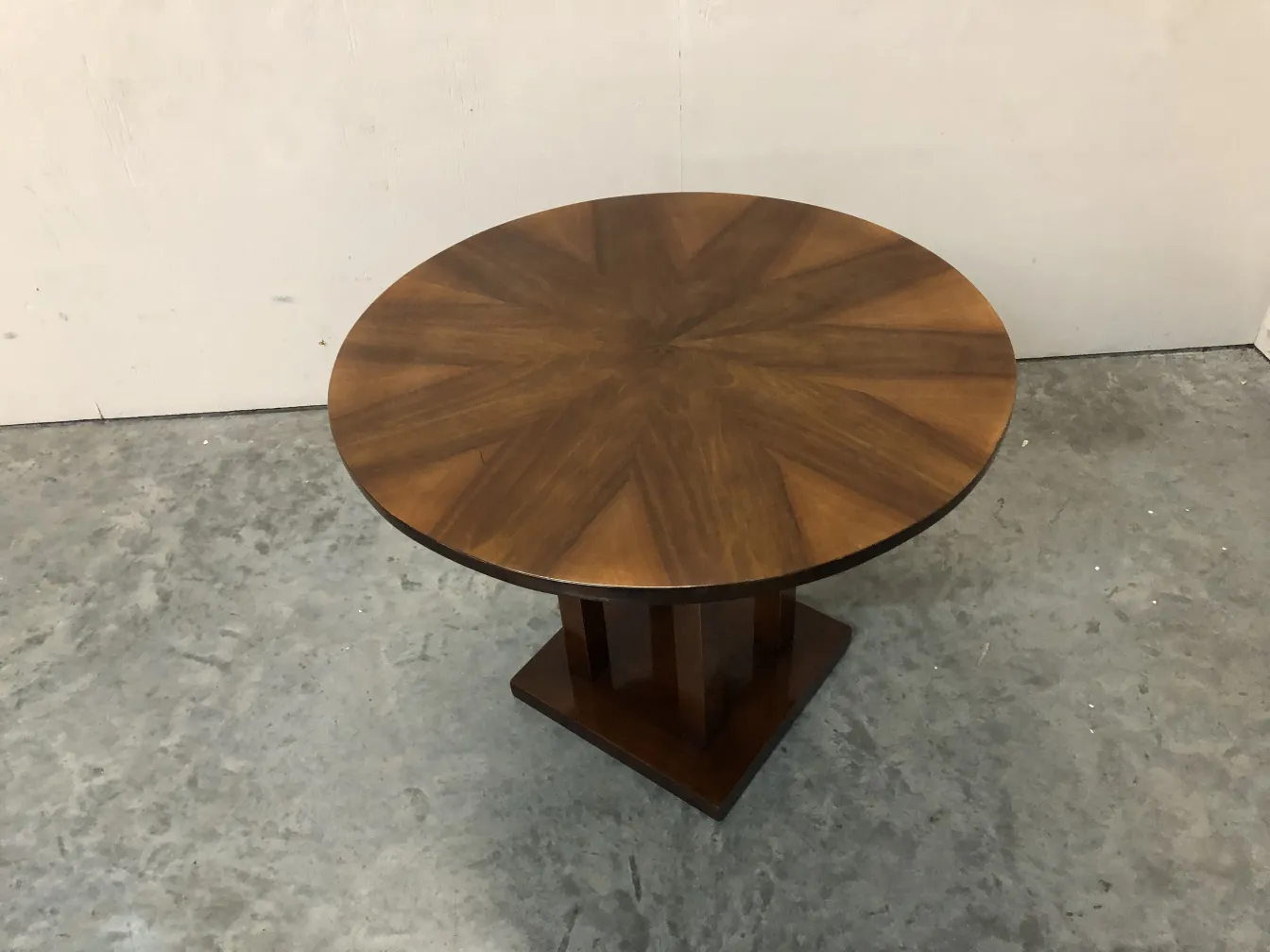 Antique round table with a design on the top surface.