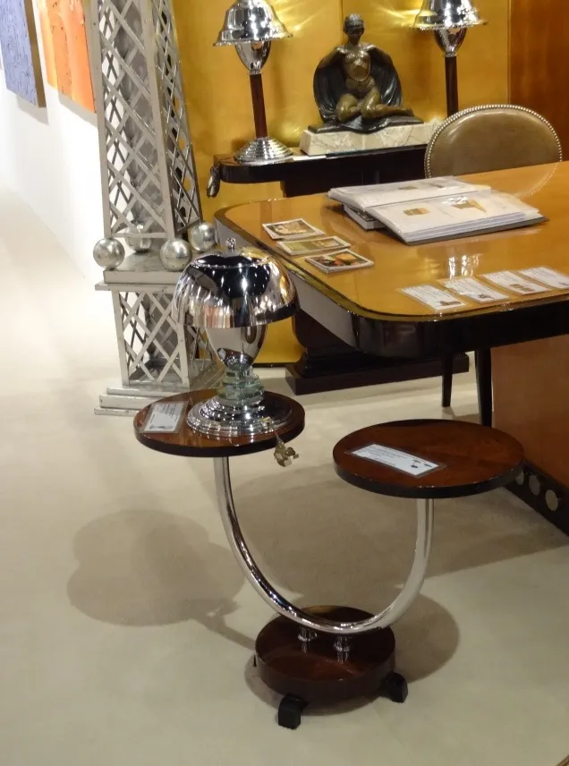 Antique small table with two tiers, modern lamp and elegant setting.