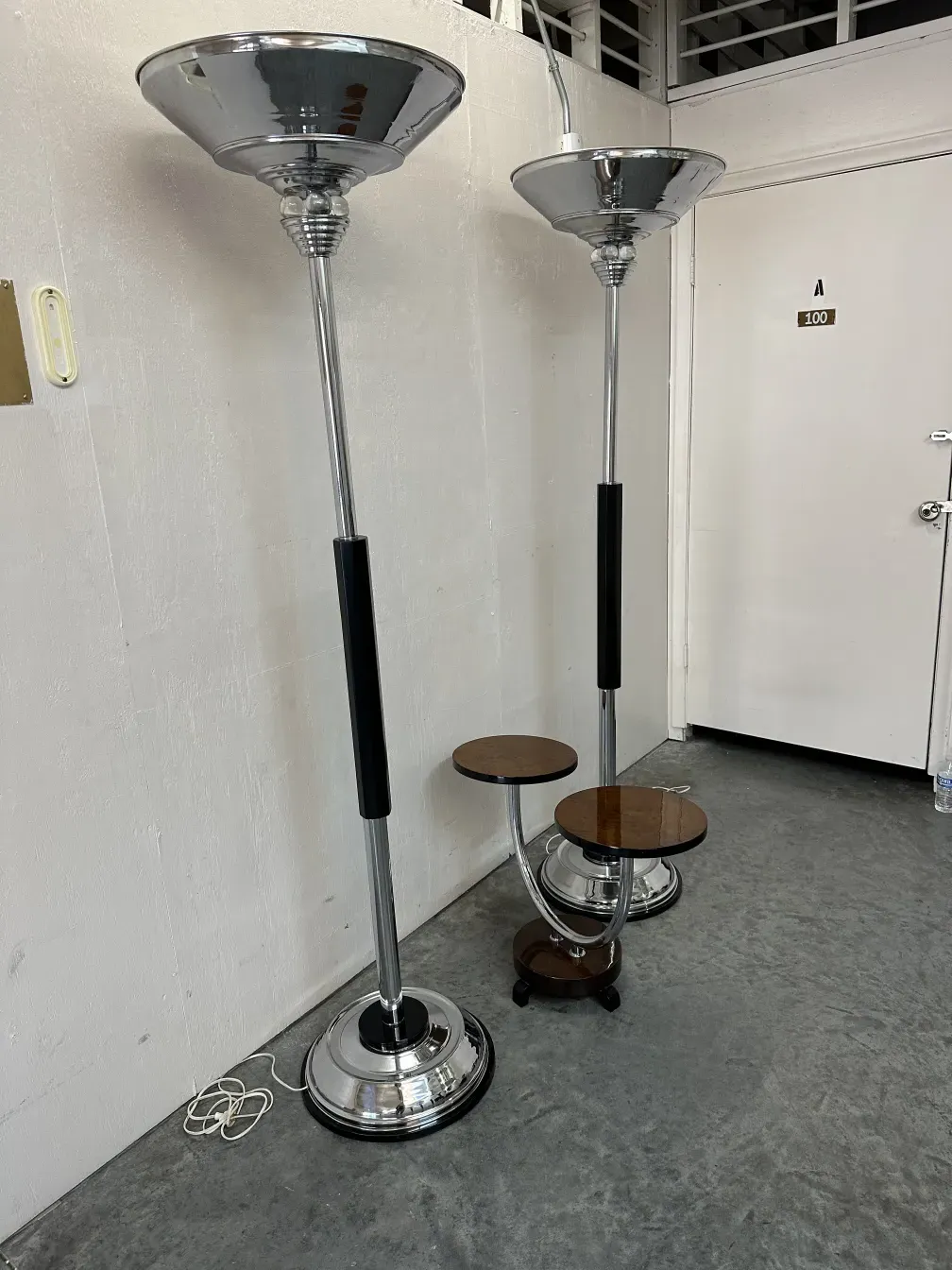 Antique small table with elegant design in a simple setting with floor lamps