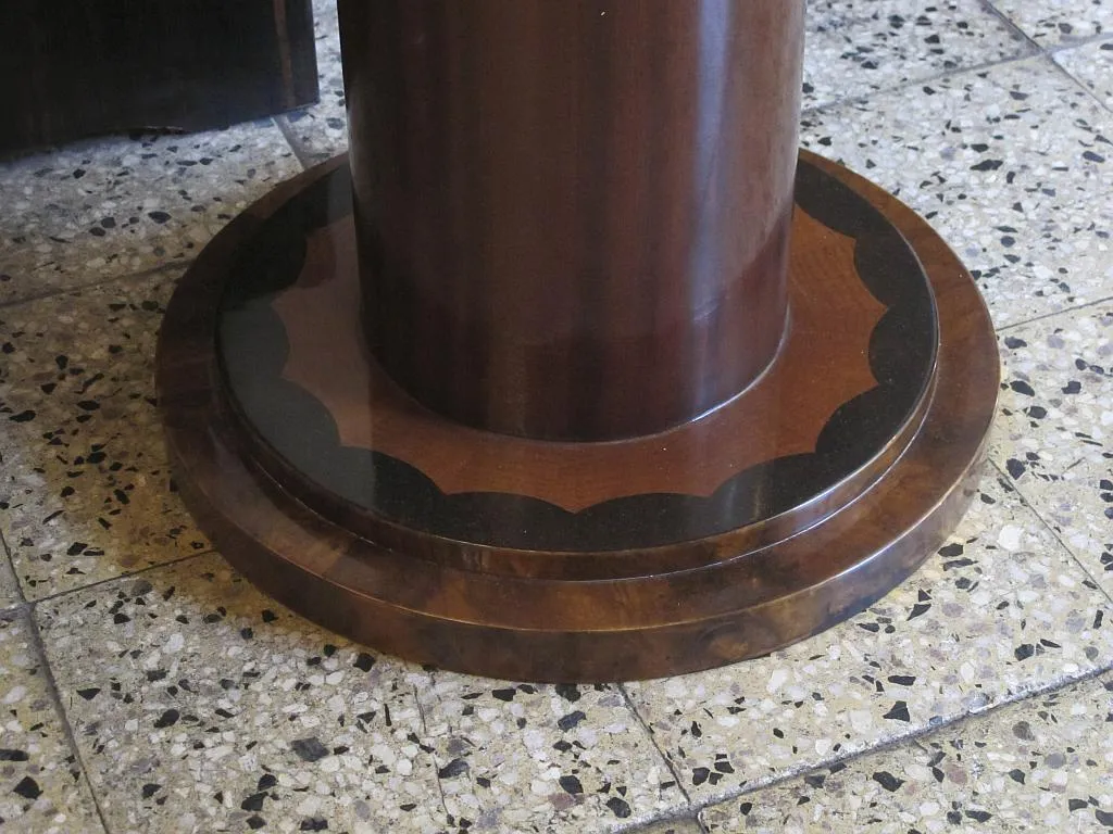 detail of the base of an antique round small table with a decorative leg