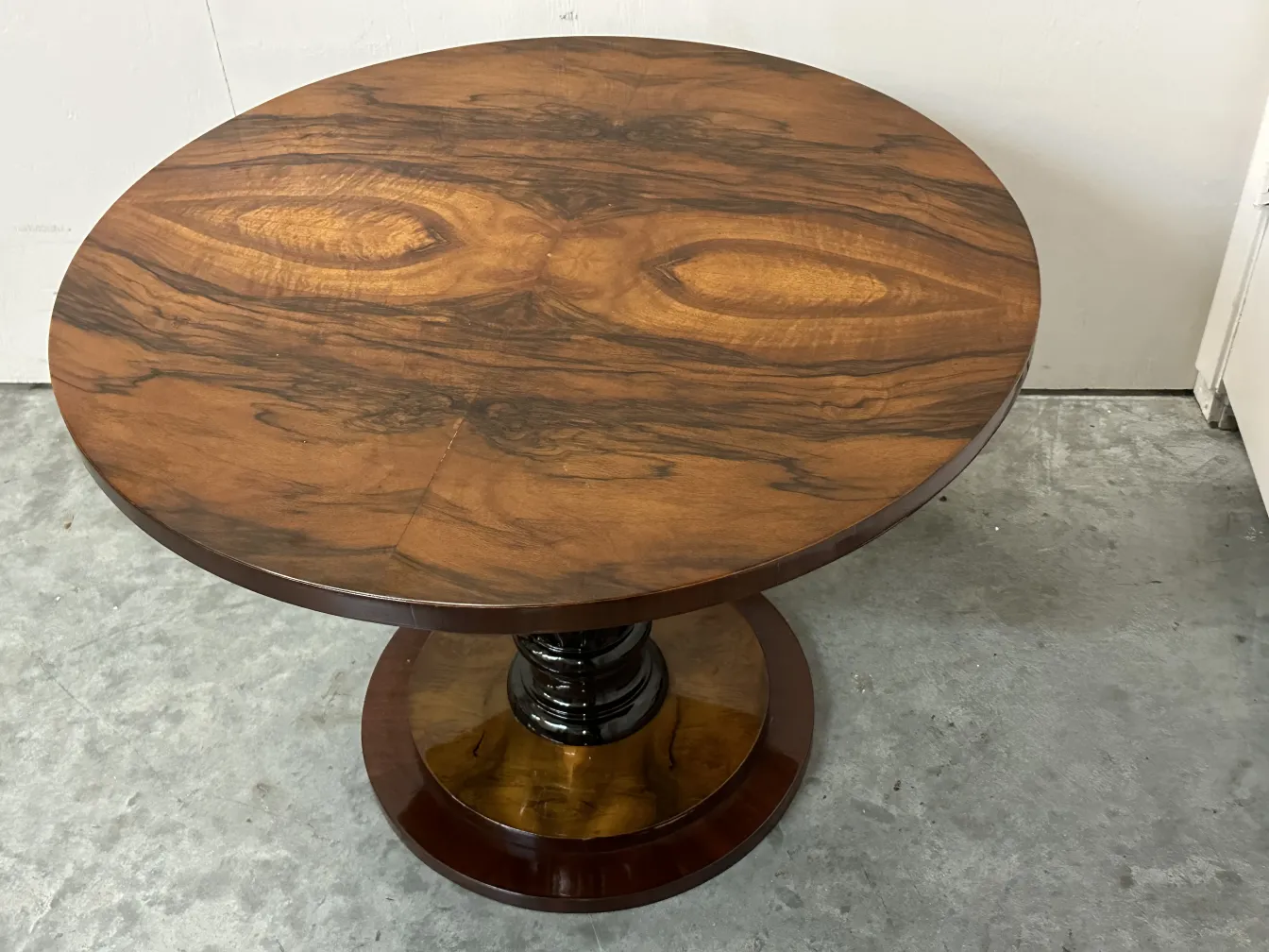 Two small antique round tables with elegant features in a simple setting