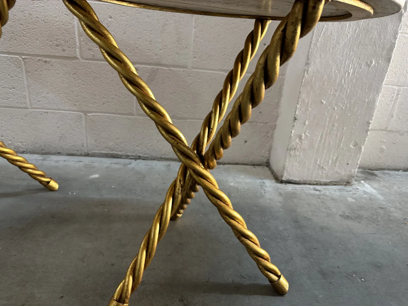 Two antique small tables with twisted gold legs in a modern setting.