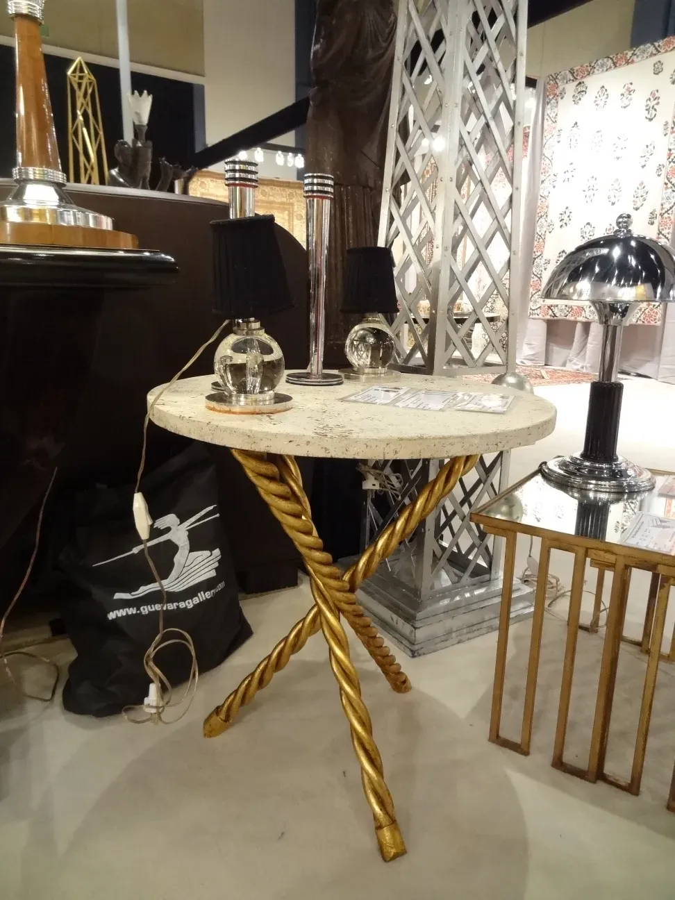 Two antique small tables with golden legs in a decorative setting