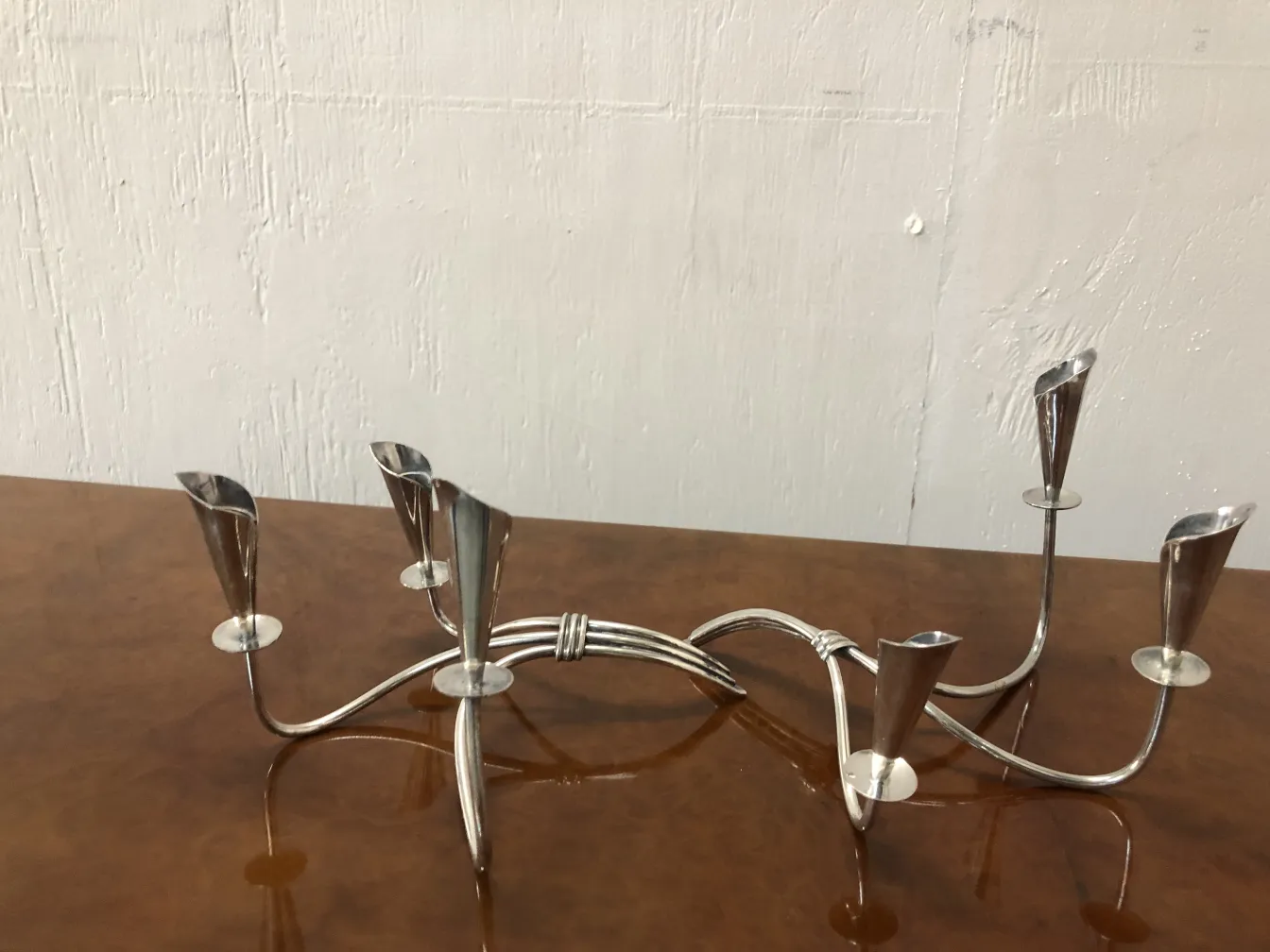 Two antique candlesticks with an elegant and decorative design on a wooden table.