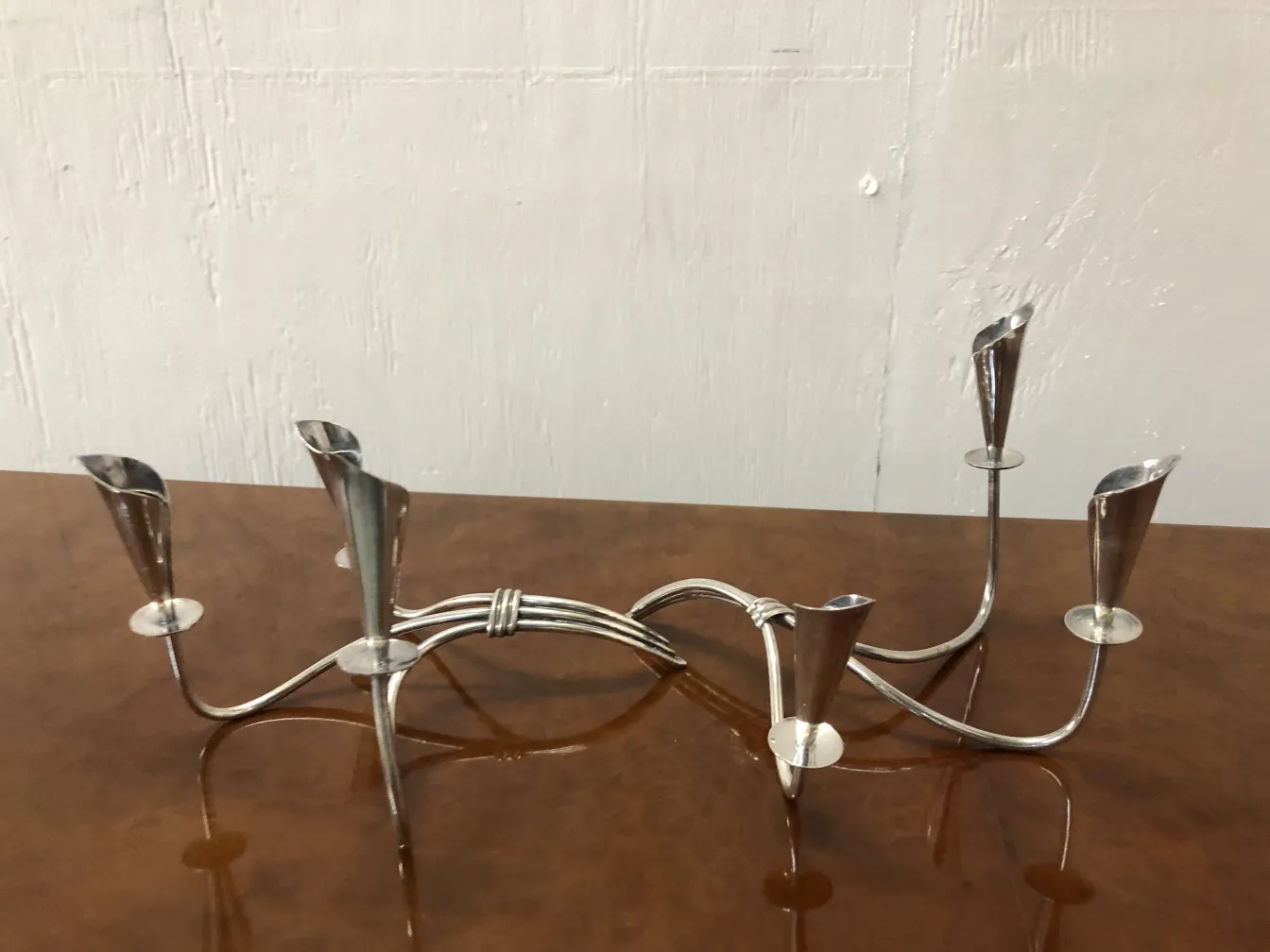 Two antique candlesticks with decorative touches, elegant shapes and shiny finish against a neutral background