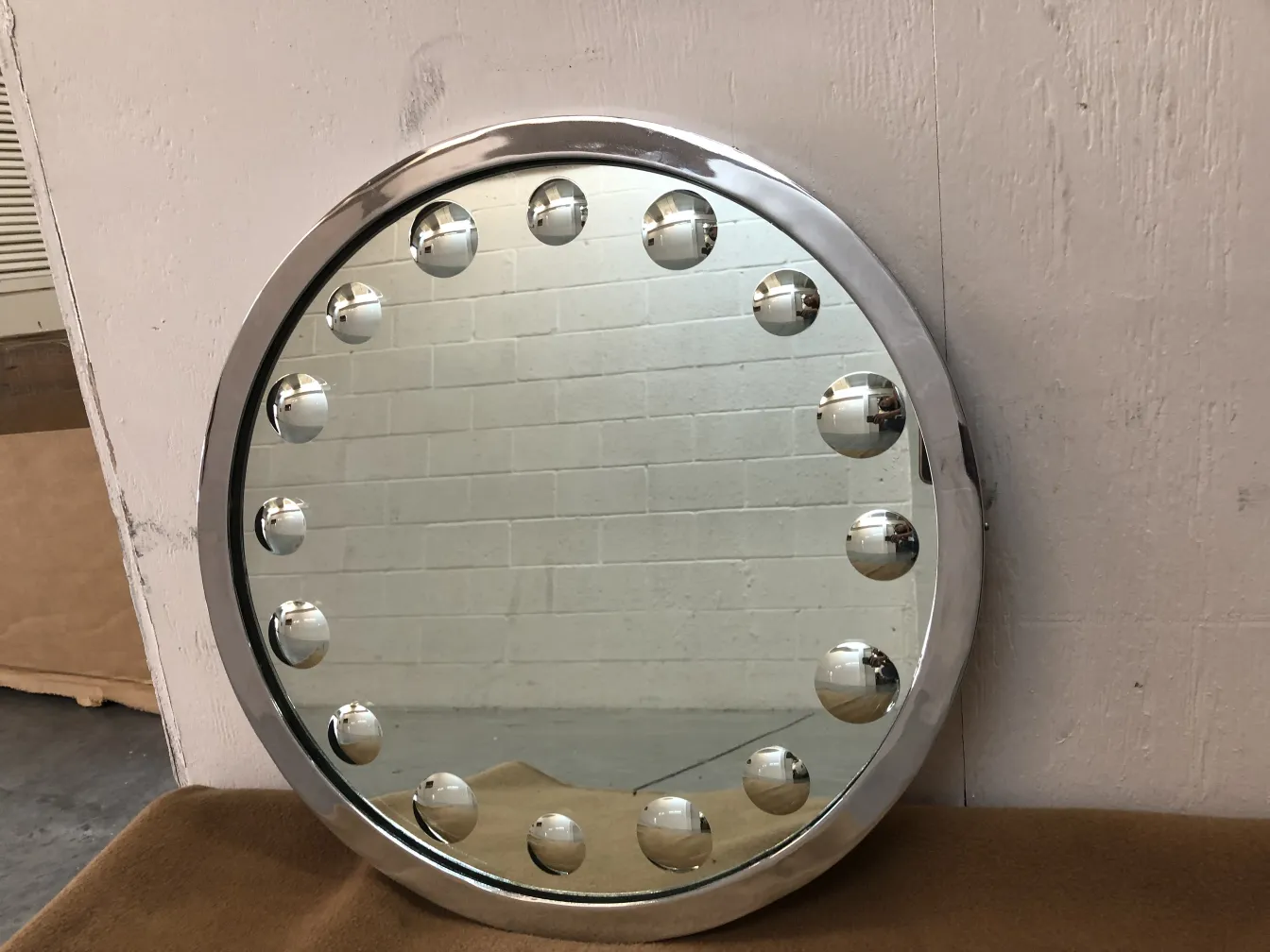 antique round mirror with lights around it