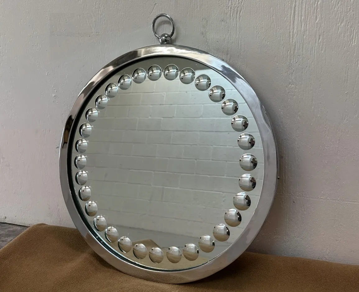 2 round antique mirrors with decorative details.