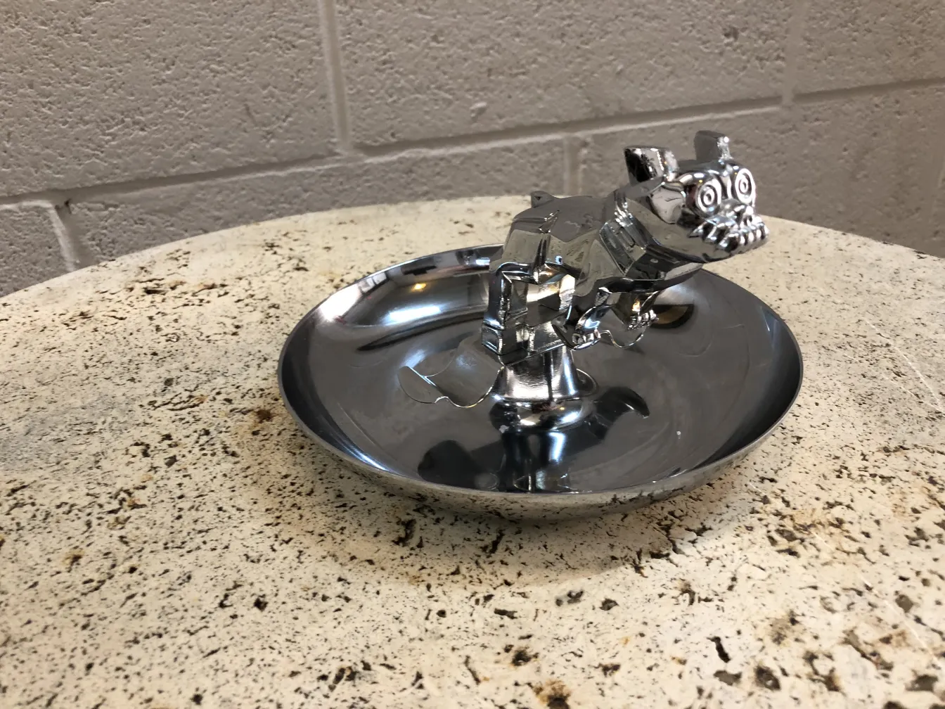 Antique ashtray shaped like a dog, shines on a table