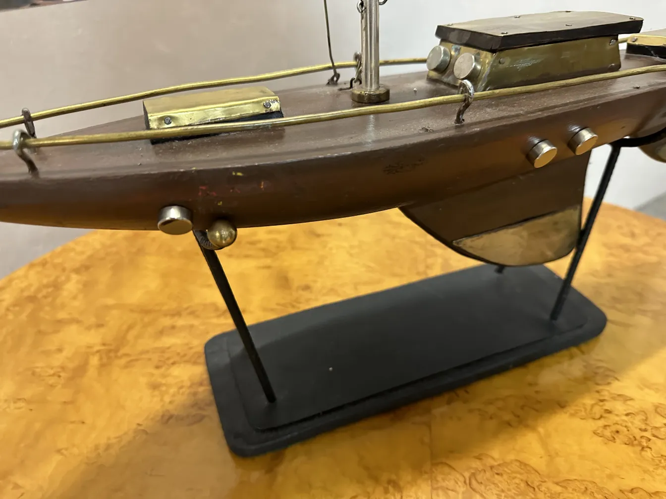 Antique designer's ship displayed on stand with decorative details.