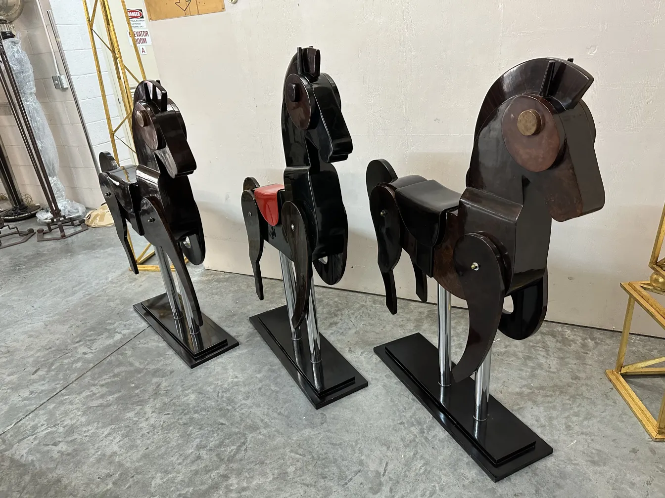 Three antique decorative horses displayed in a row.