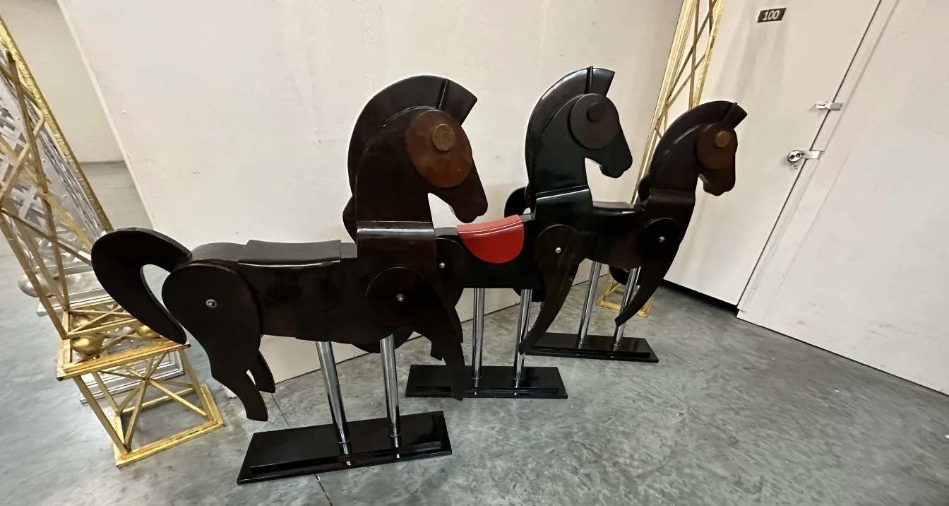 Three antique decorative horses, set in a serene environment.