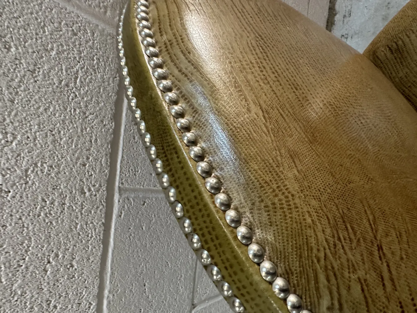 View of antique chairs featuring embossed adornments and rounded corners.