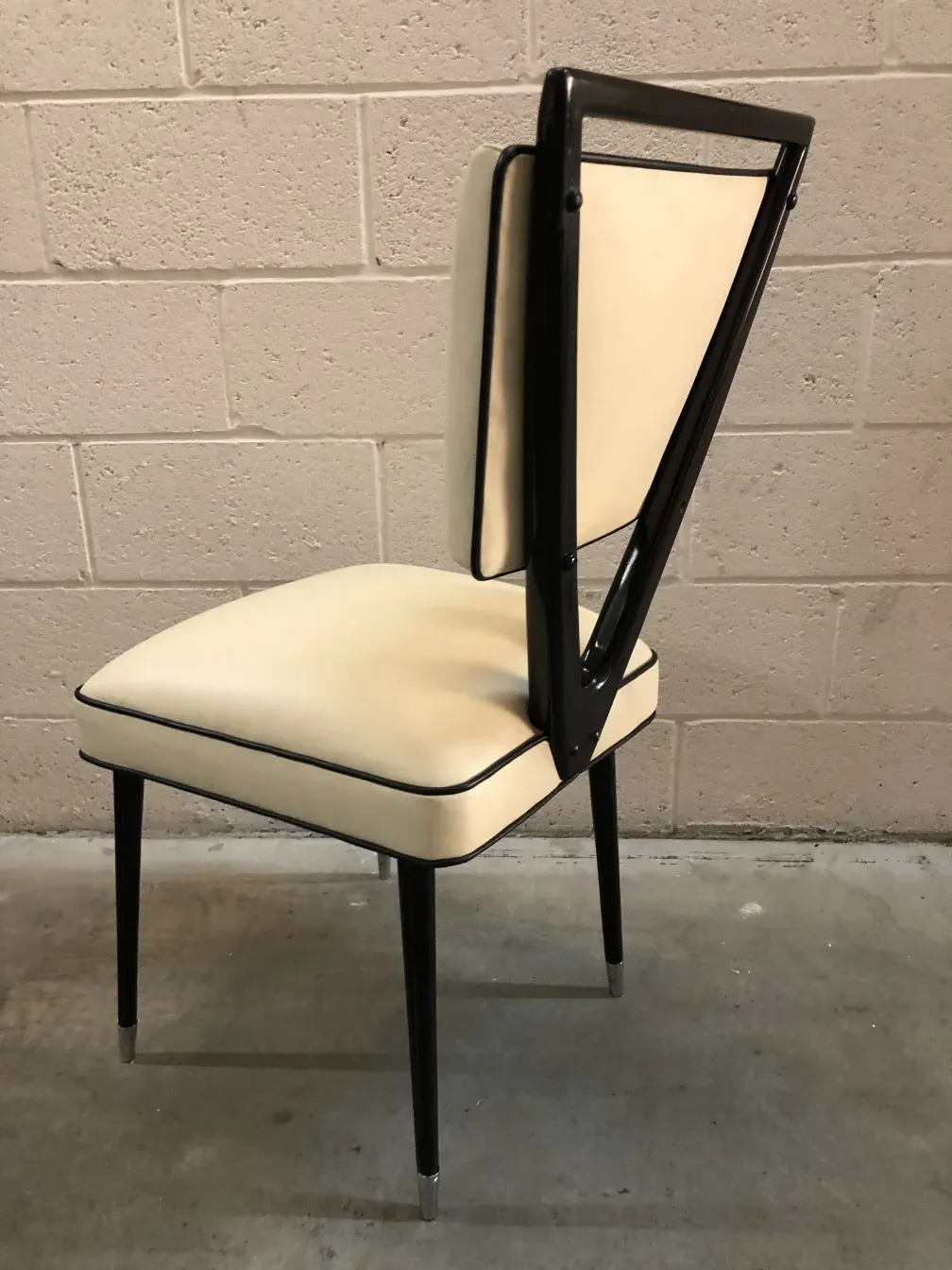 Two antique chairs designed by carlo mollino in a neutral setting.