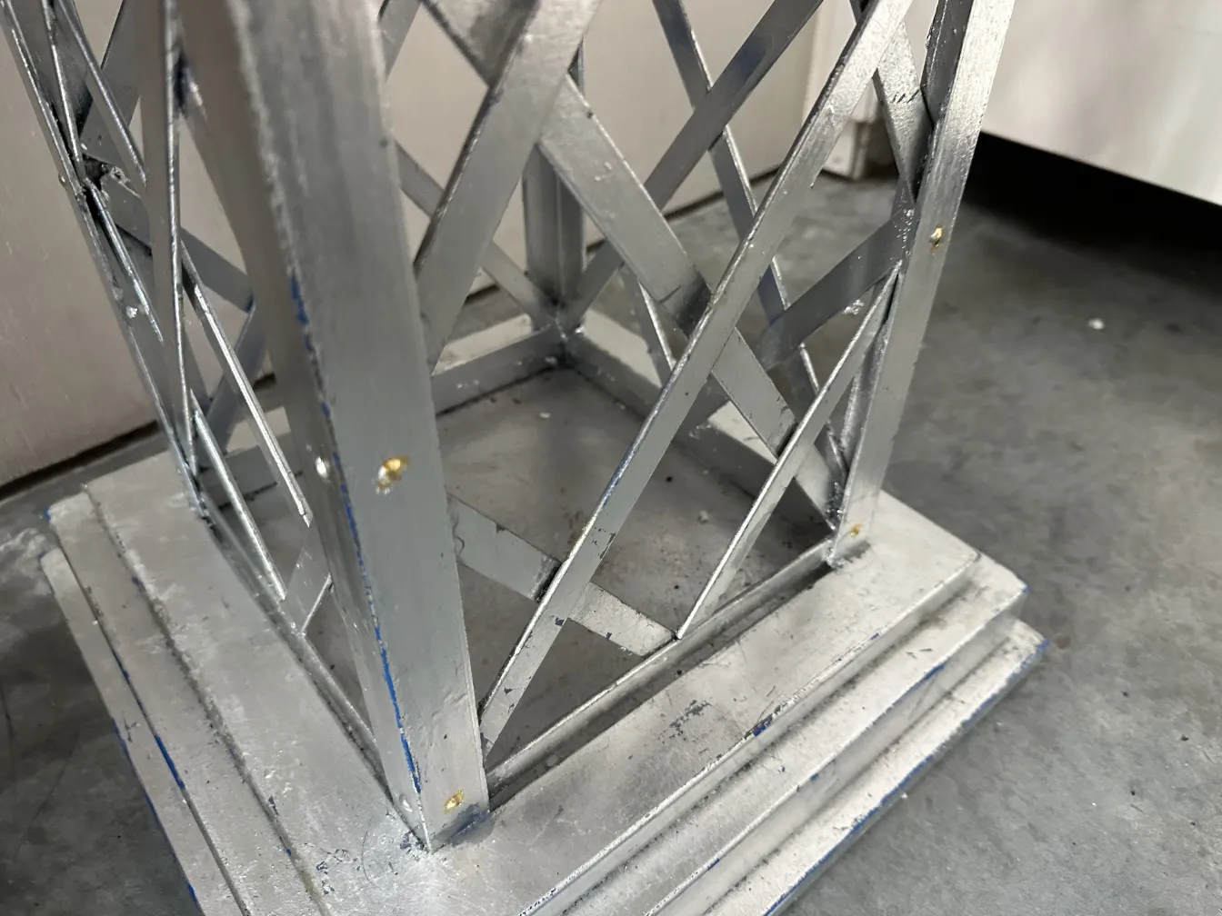 Antique decorative obelisk with ornate base and intricate design against a subtle backdrop