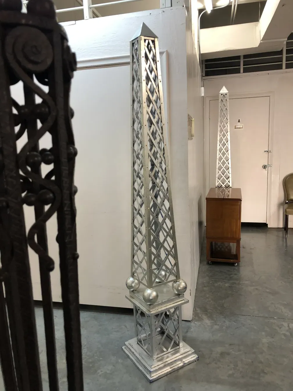 Antique decorative obelisk with geometric design, light background.