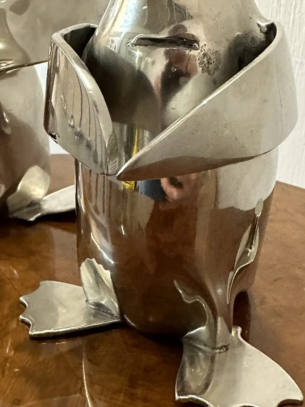 antique sculpture of two penguins against a wooden background