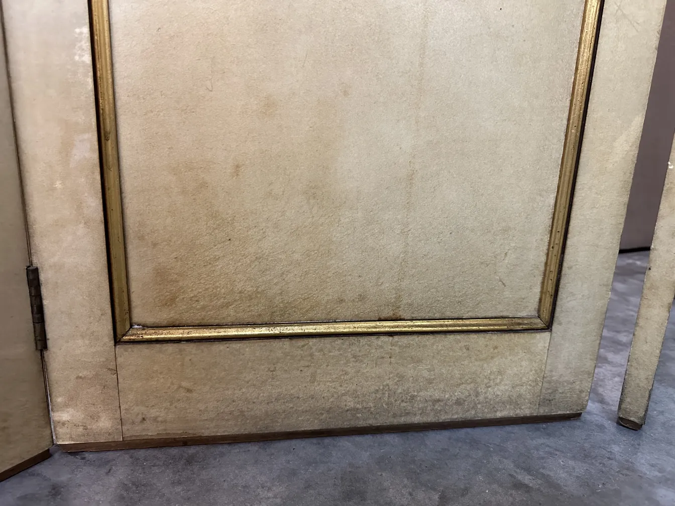 close-up of an antique folding screen with a gold frame