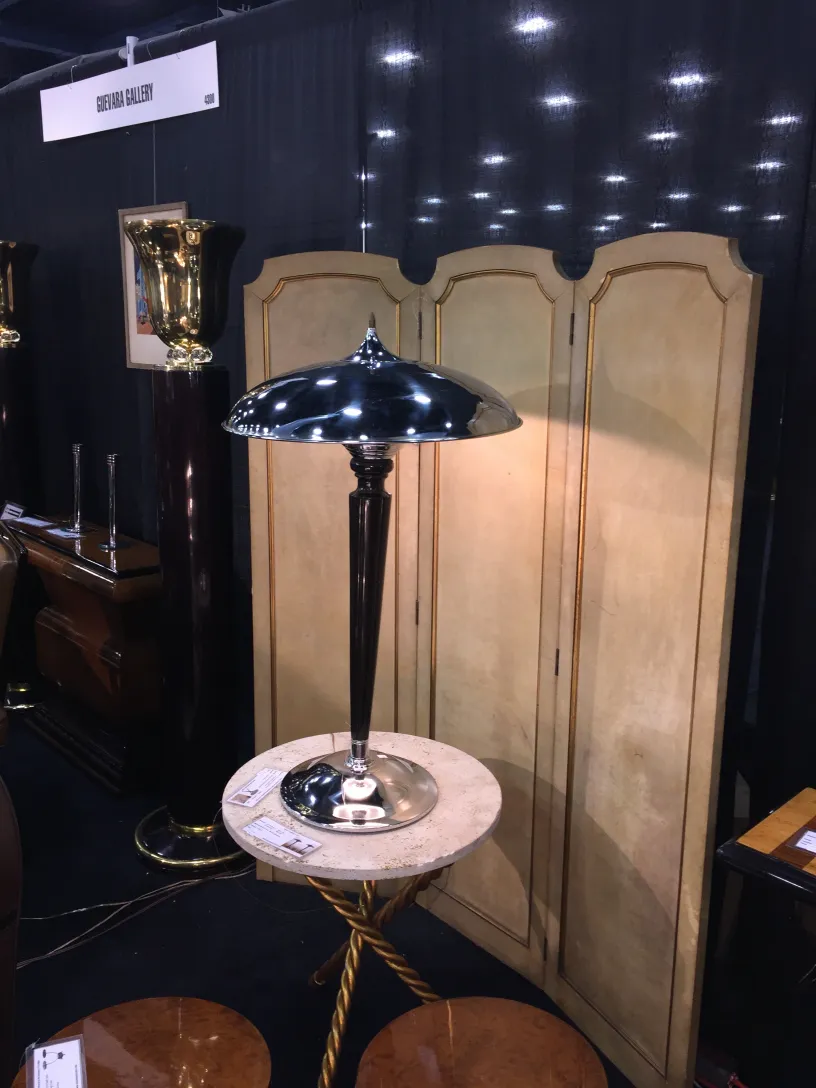 2 antique folding screens by Adolphe Chanaux on display, dark background