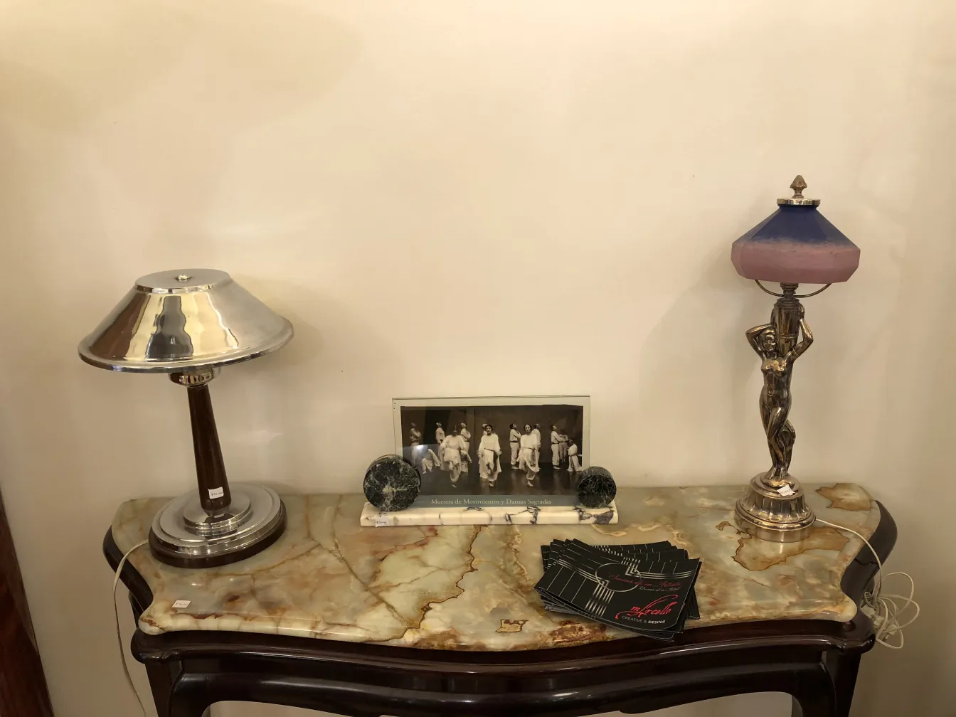 Antique picture frame decorated with a black and white image, accompanied by lamps and decorative items on a table.