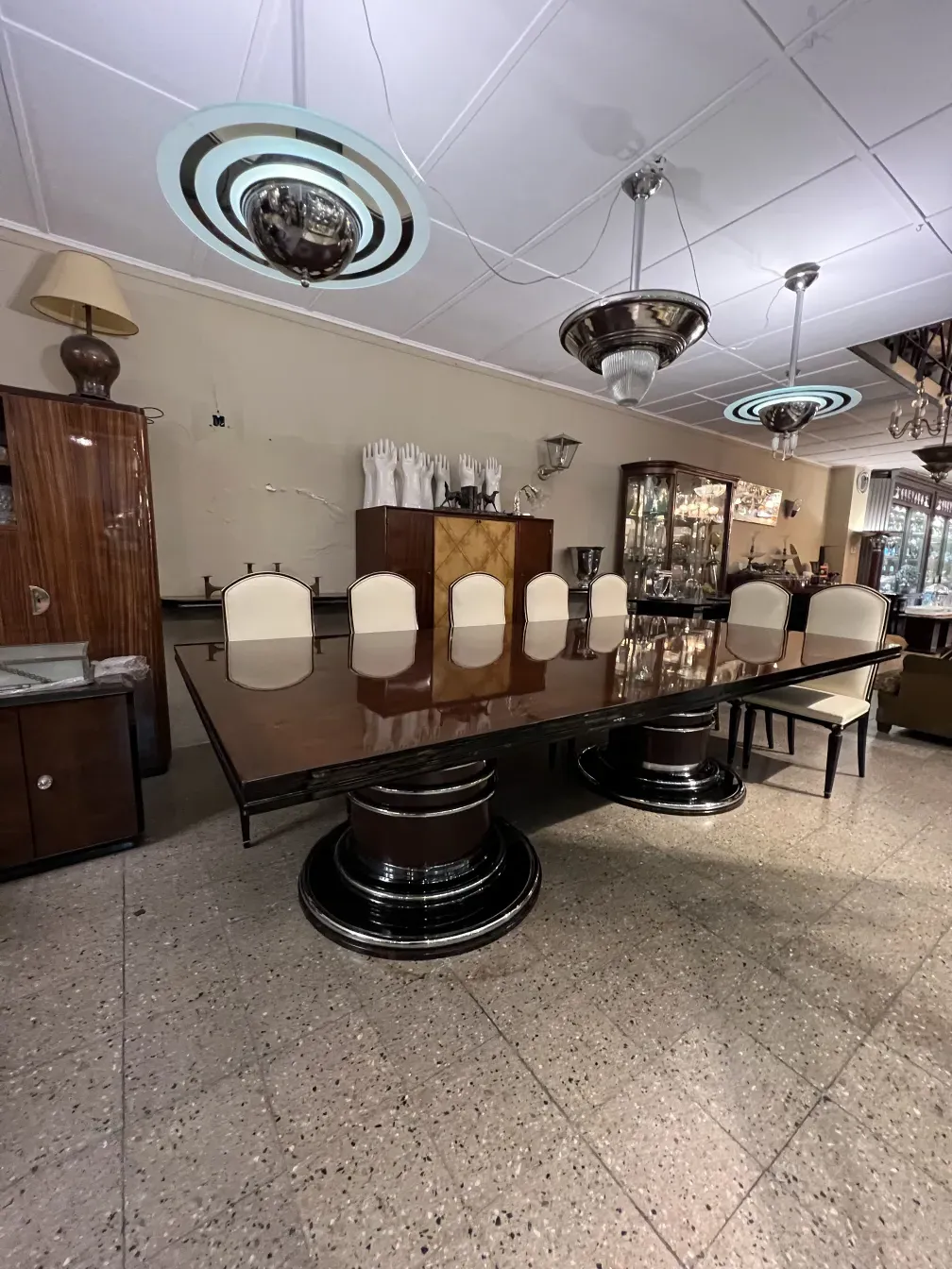 antique dining table for 14 people with white chairs in an elegant setting