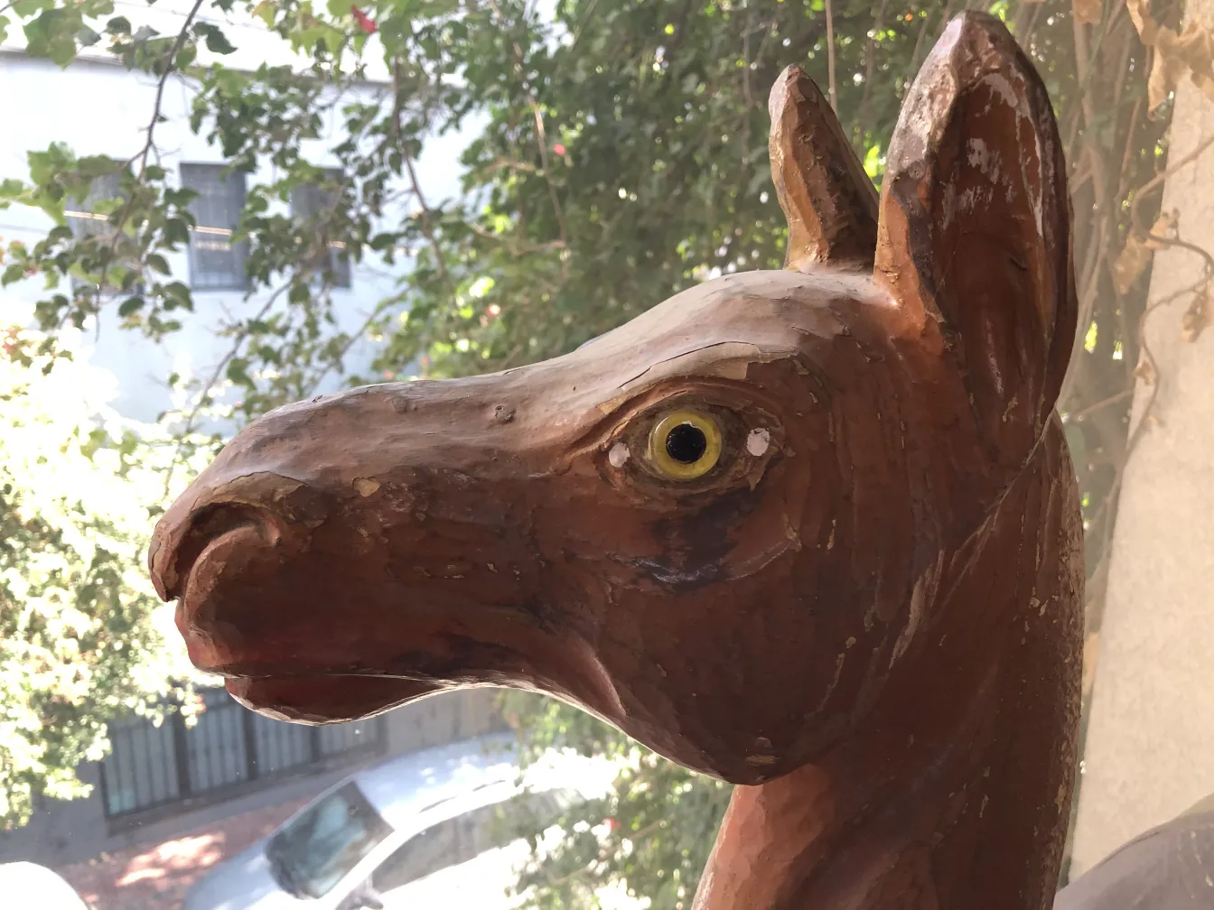 Antique llama sculpture with yellow eyes.