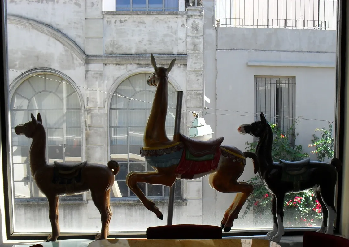 Antique decorative llama with vibrant colors by the window.