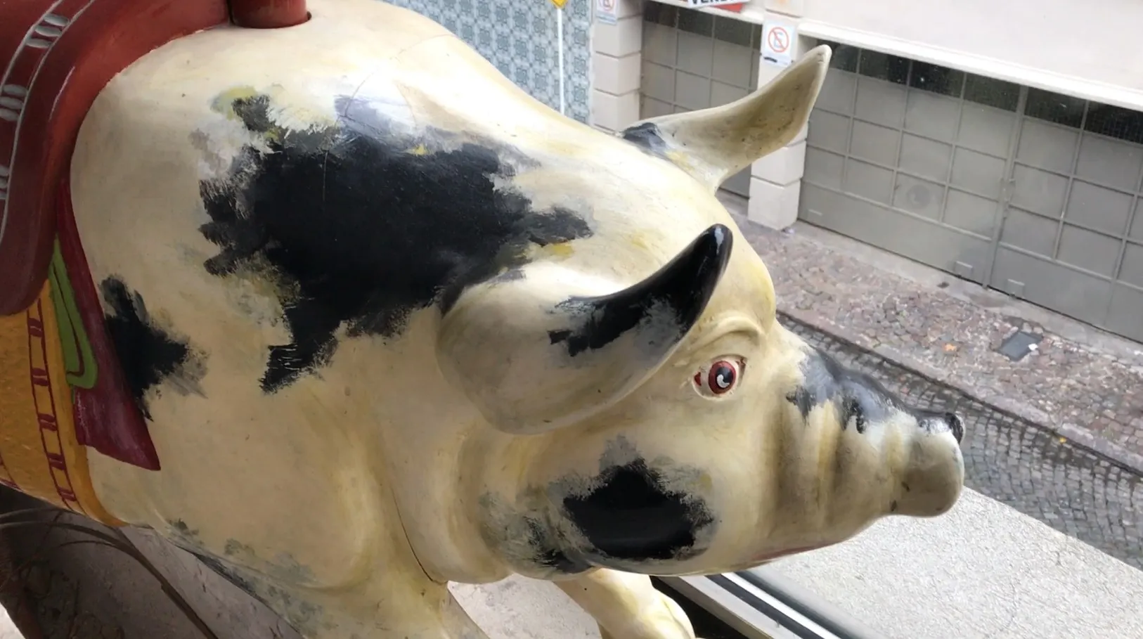 Decorative antique pig with black and white detailing and a red eye.