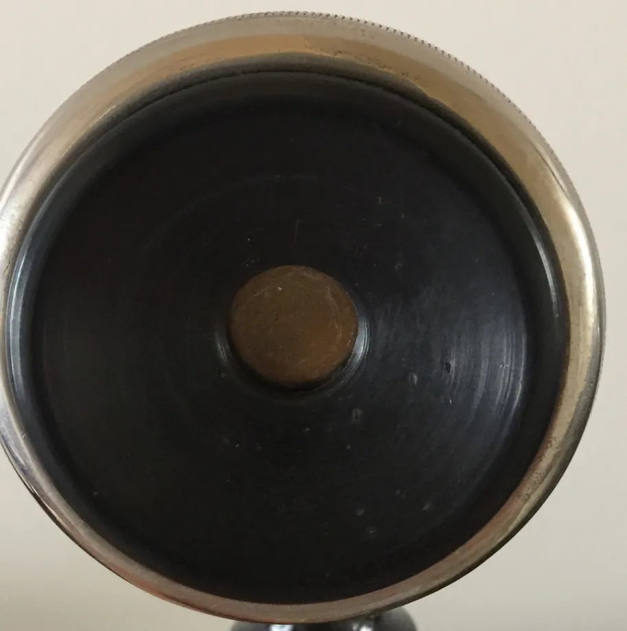 top view of an antique phone with round base and central button