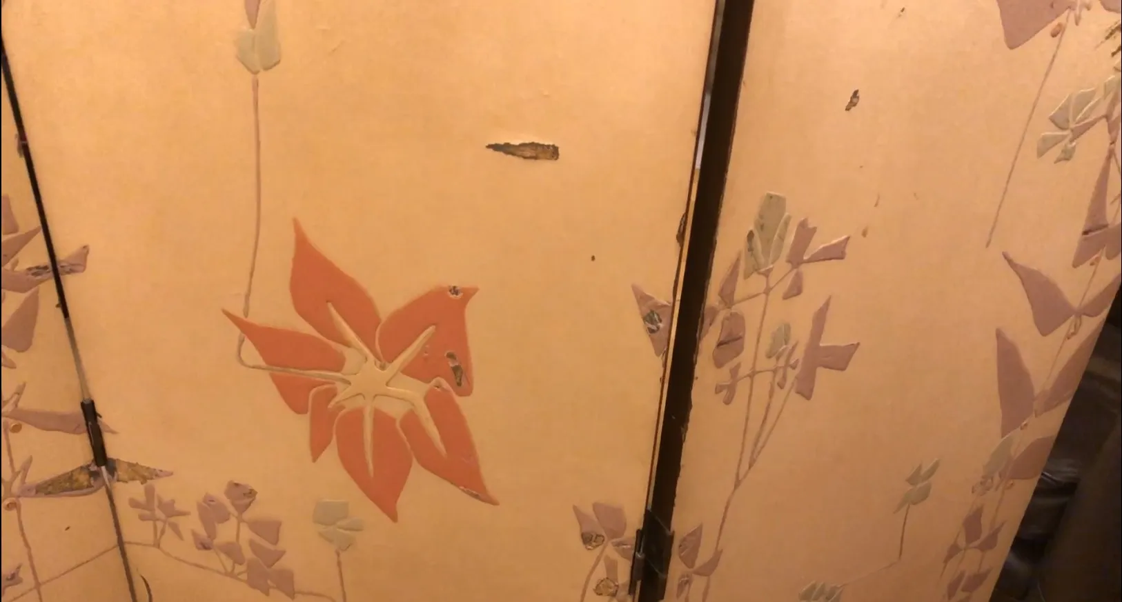 Antique folding screen featuring floral patterns in soft colors.