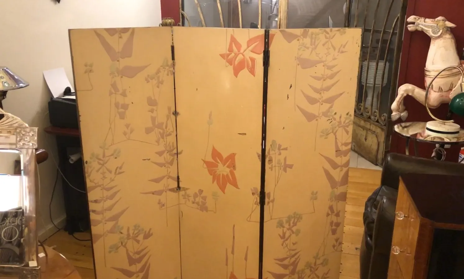 antique folding screen with floral pattern in a decorated room