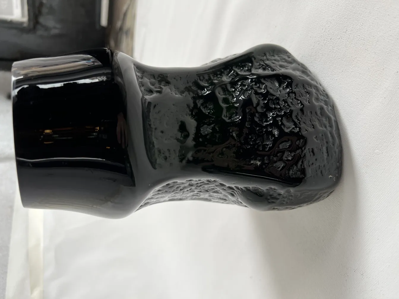 vaso antico nero con texture unica, su sfondo neutro
