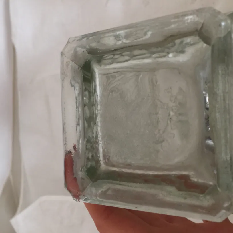 vase antico in vetro con forme decorative, sfondo neutro