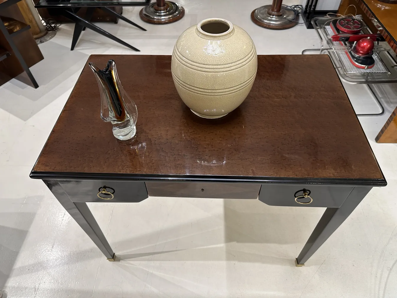 Antico vaso decorativo in ceramica, stile semplice, finitura chiara, in un ambiente elegante con un tavolo in legno.