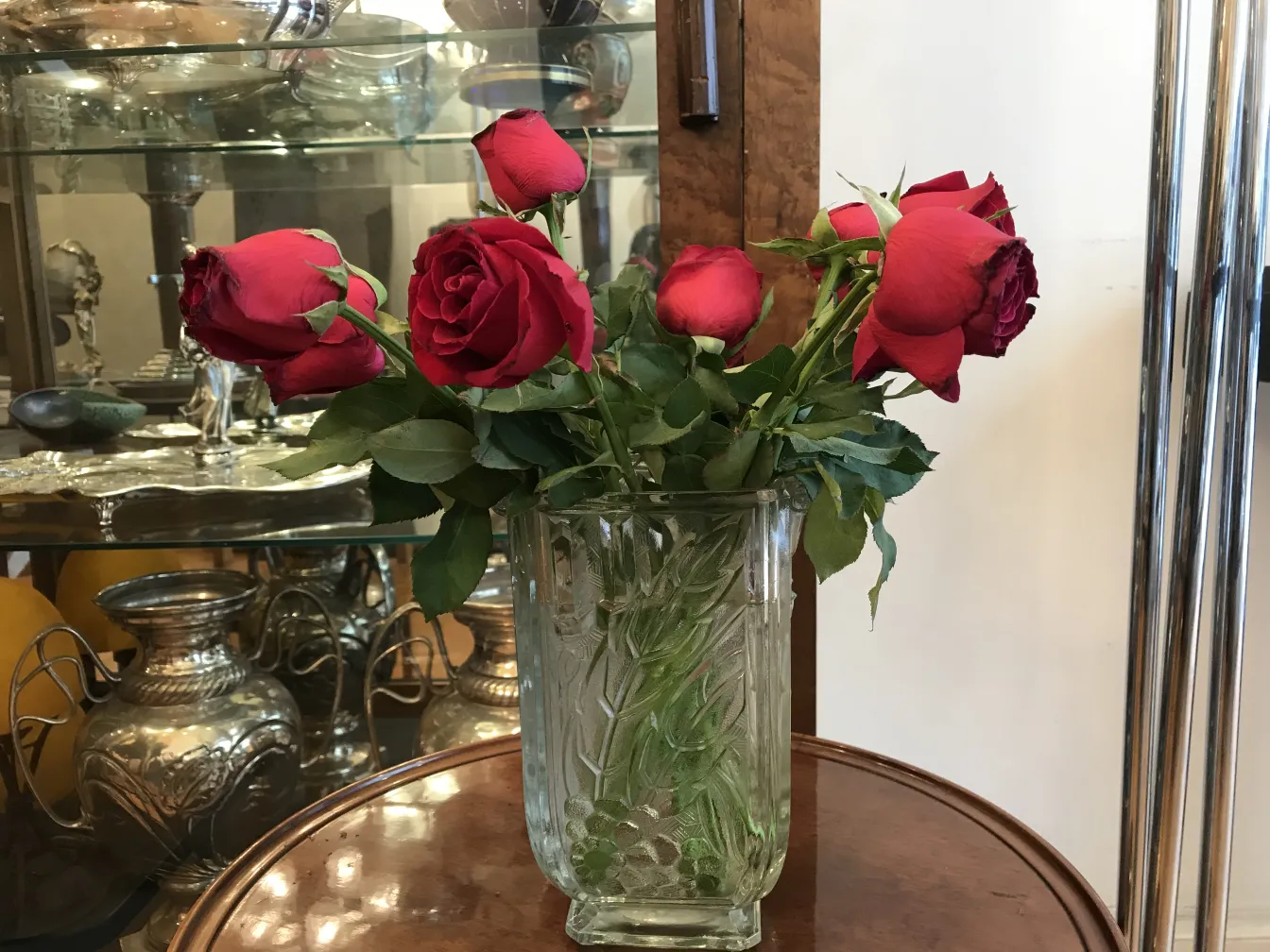 vase antico decorato con dettagli, pieno di rose rosse
