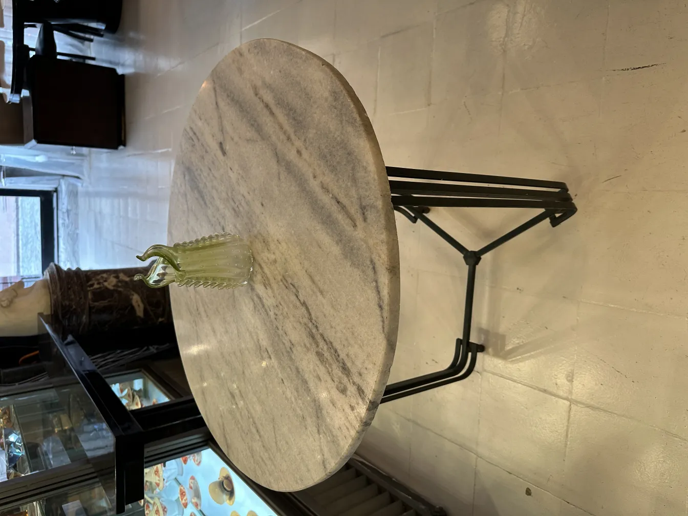 vaso antico in vetro verde su un tavolo in un ambiente decorato elegantemente