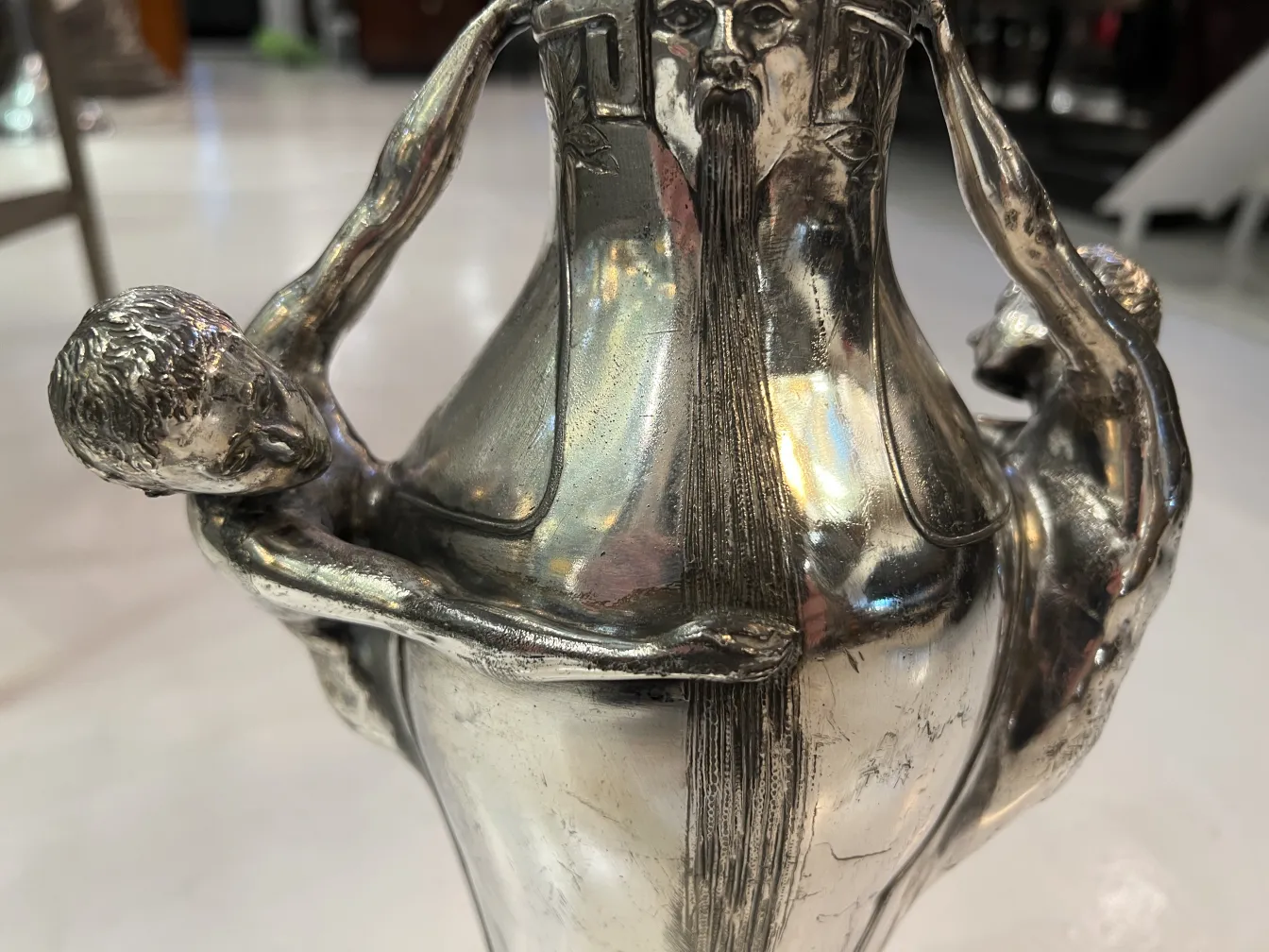 Vaso antico con figure artistiche e dettagli unici, ambiente elegante.