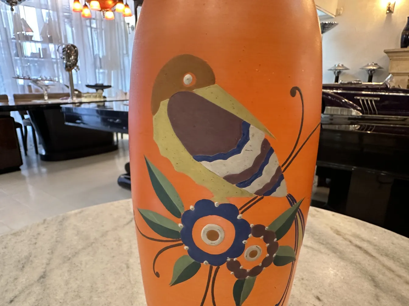 vaso antico in ceramica con dettagli di uccelli e fiori, ambientato in uno sfondo moderno