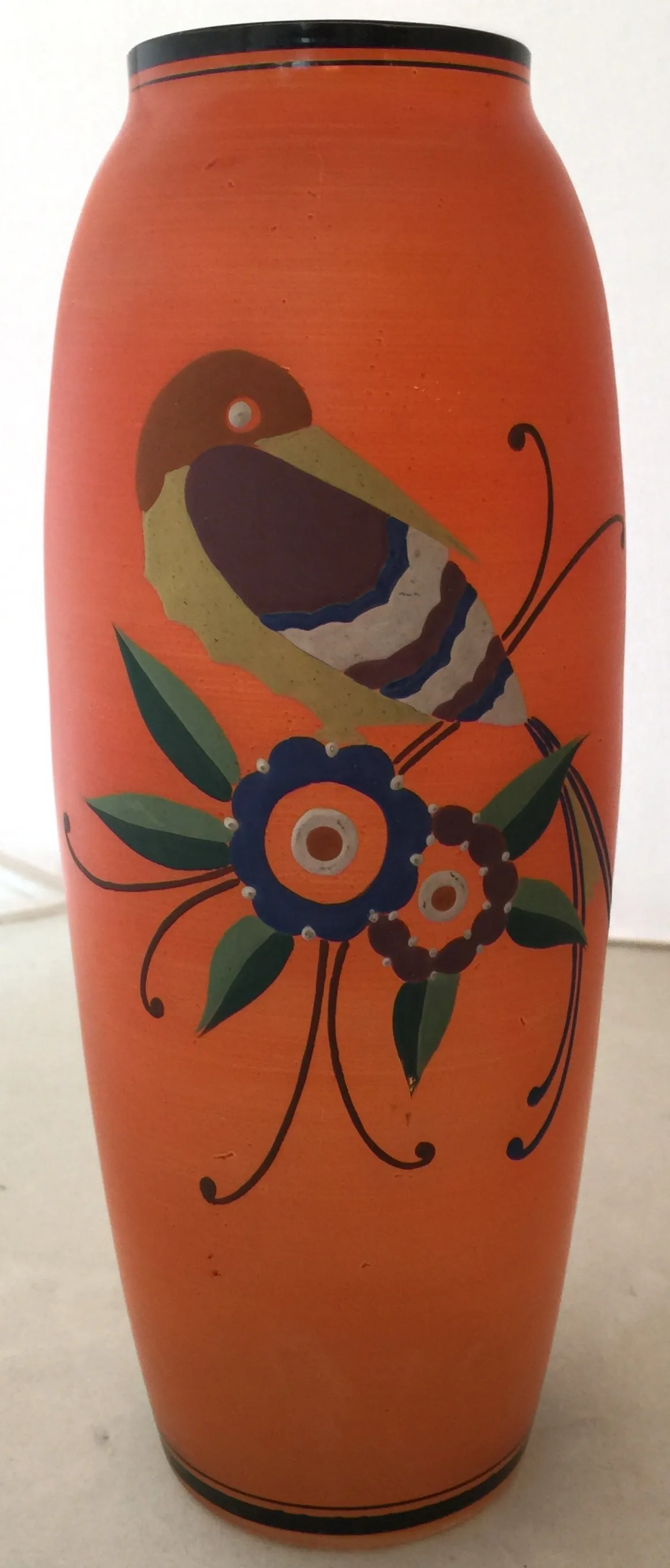 vaso antico luminoso con illustrazioni di uccelli e fiori su sfondo arancione