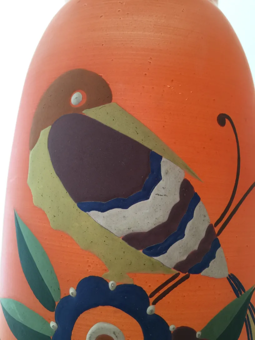 vaso antico con uccello e fiori dai colori vivaci