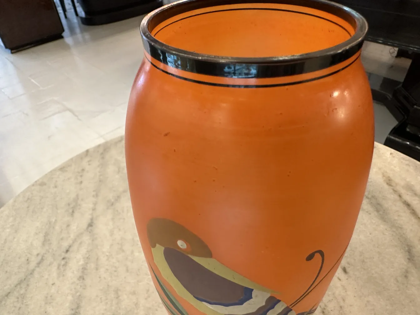 vaso antico arancione, splendidamente decorato con forme colorate in un ambiente elegante