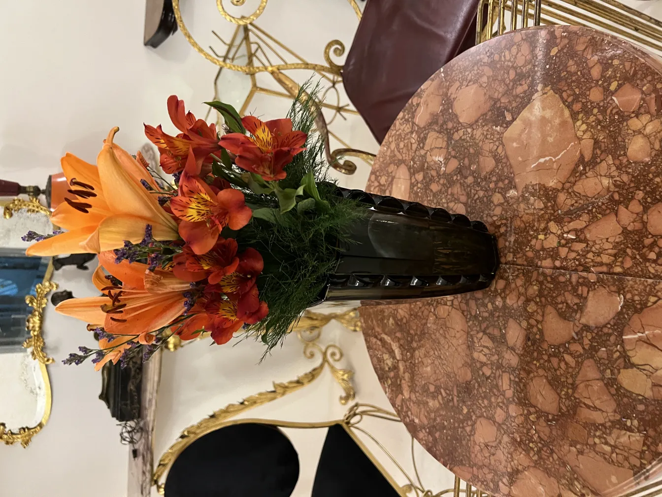 vano antico decorato con gigli e fiori rossi su un tavolo