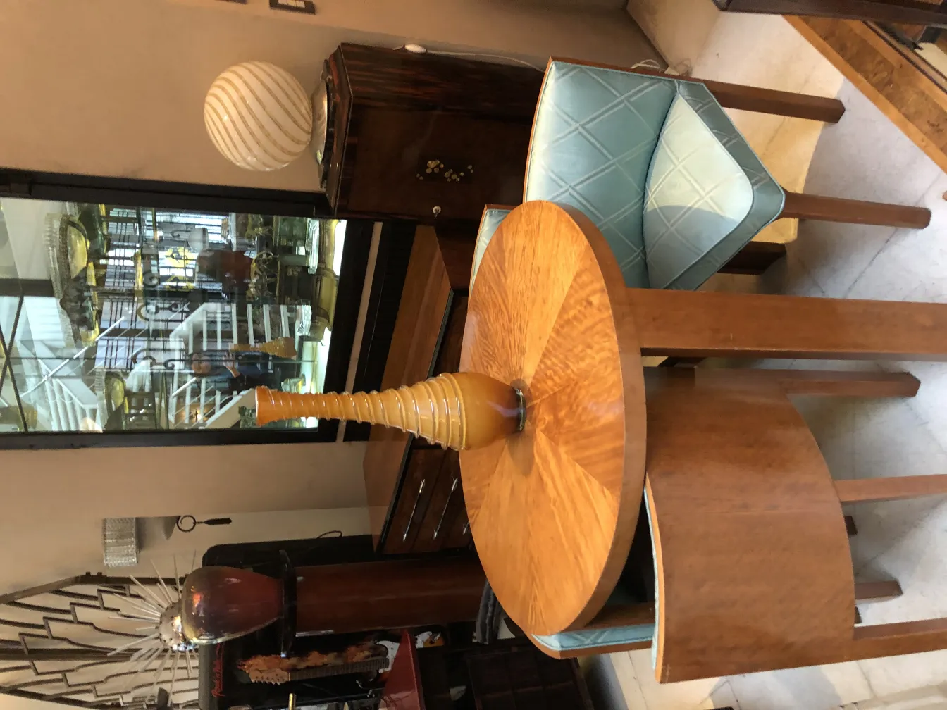 Vaso antico decorativo con design alto e snello su tavolo in legno, atmosfera calda.